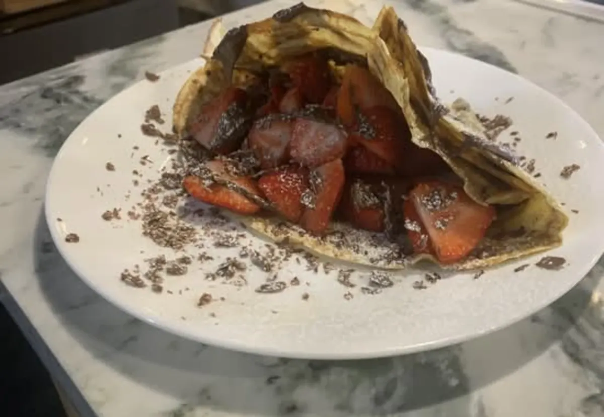 Strawberry and chocolate crêpe served with a cacao kiss smoothie on the marble counter